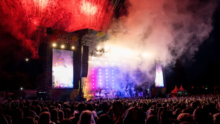 Die Hauptbühne auf dem Juicybeats 2023 bei Nacht mit rotem Feuerwerk im Hintergrund