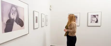 Eine Frau sieht sich Bilder in einer Ausstellung an.