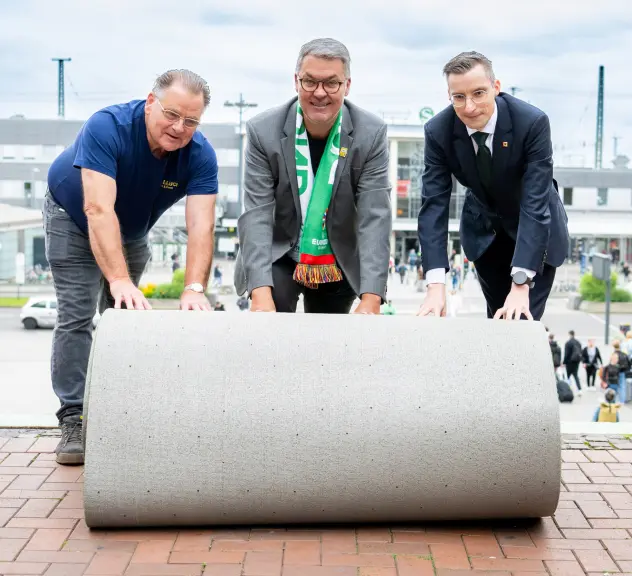 Manfred Schepp, Oberbürgermeister Westphal und Martin Sauer rollen den grünen Teppich aus