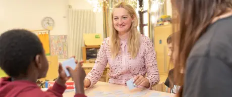 Svitlana Bondar spielt mit Kindern im Gruppenraum Memory.