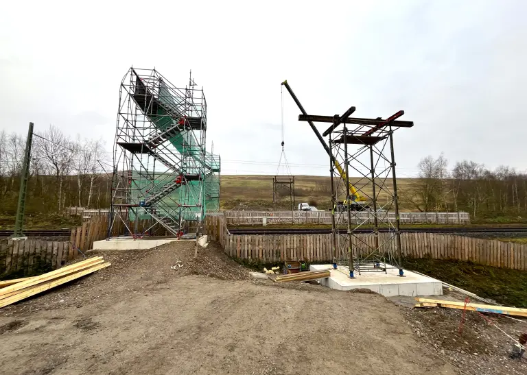 IGA 2027: Mittelteil der Brücke „Haldensprung“ schwebt über Bahngleisen ein.