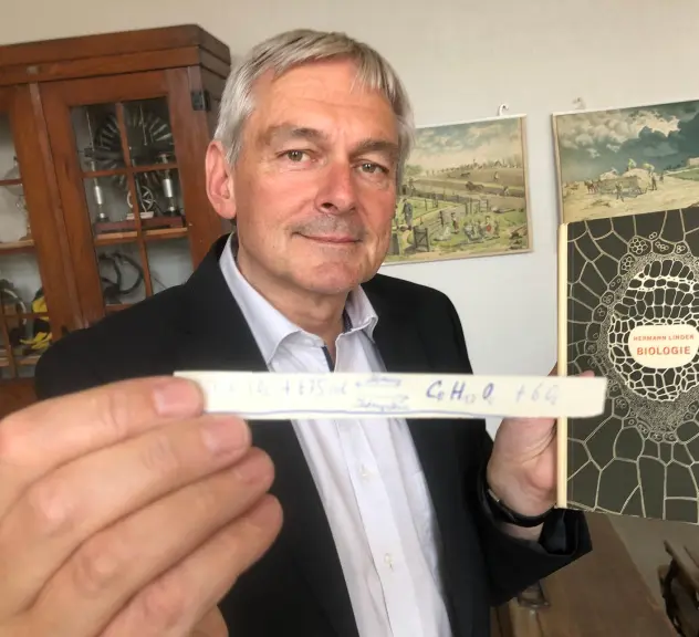 Michael Dückershoff zeigt einen Spickzetten und das Biobuch, in dem er gefunden wurde, zur neuen Sammlung von Spickzetteln im Westfälischen Schulmuseum.