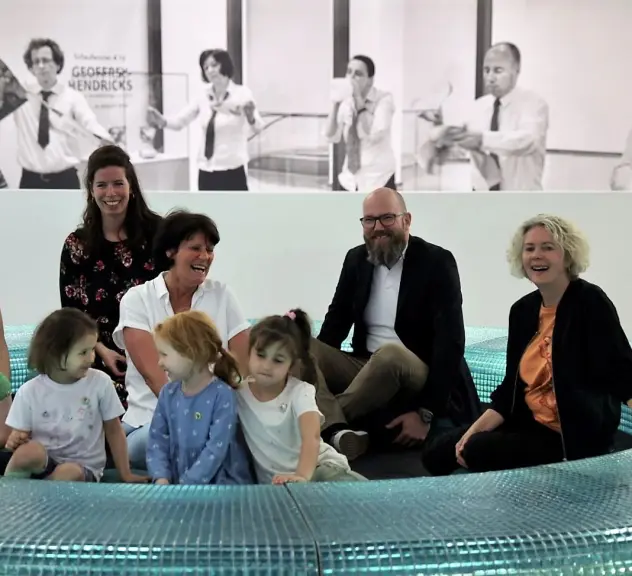 Vertreterinnen und Vertreter der Institutionen Fabido und Museum Ostwall im Dortmunder U sitzen mit vier Kita-Kindern einer Fabido-Kita in einem Ausstellungsstück im Museum Ostwall.