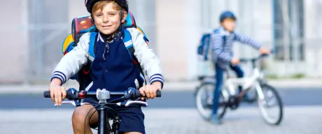 Kind fährt mit dem Fahrrad zur Schule.