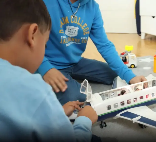 Kinder spielen mit Playmobil-Flugzeug