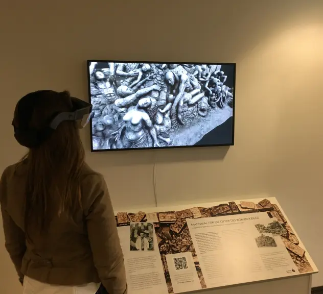 Eine Frau mit Virtual-Reality-Brille schaut auf einen Bildschirm.