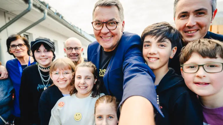 OB Westphal (in der Mitte) macht ein Selfie mit Kindern und erwachsenen Personen. Alle lachen in die Kamera.