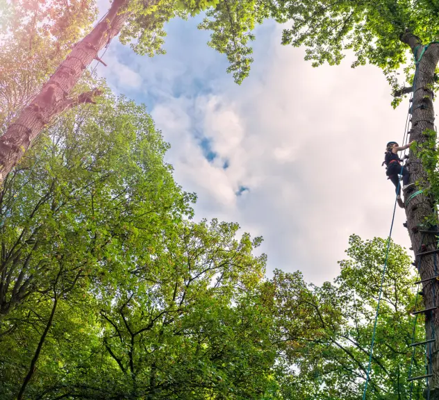 Ein Kind beim Klettern in den Bäumen im größten Indianerzelt der Welt, dem Big Tipi in Dortmund.