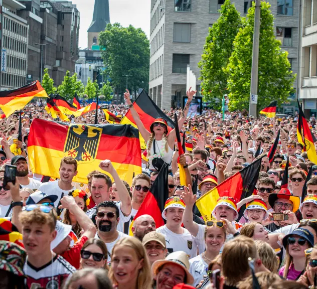 Eine Menschenmenge während der Europameisterschaft 2024 in Dortmund mit Deutschlandflaggen.