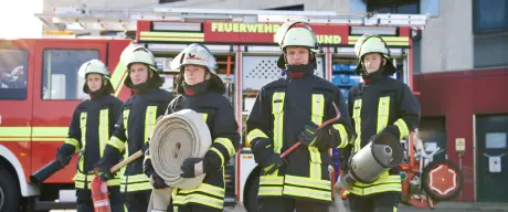 Mitarbeitende der Feuerwehr Dortmund vor einem Löschfahrzeug