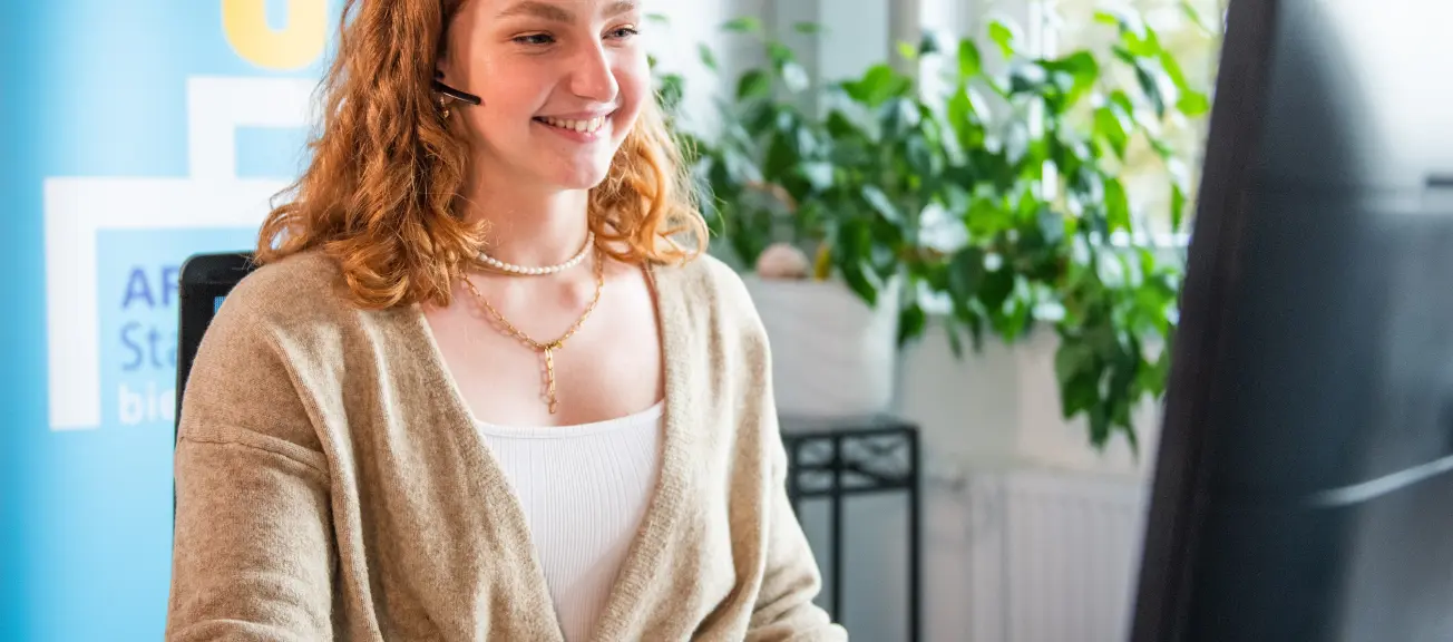 Eine junge Frau, welche auf dem Computer etwas nachschaut 