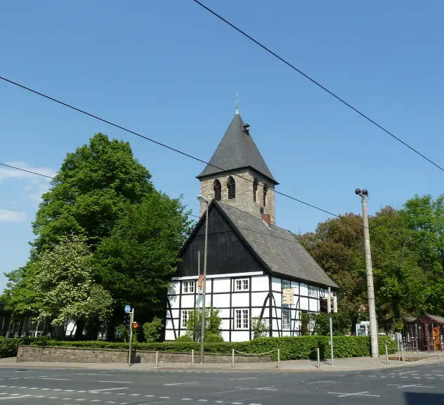Eine alte Kirche mit Fachwerkhaus im Vordergrund