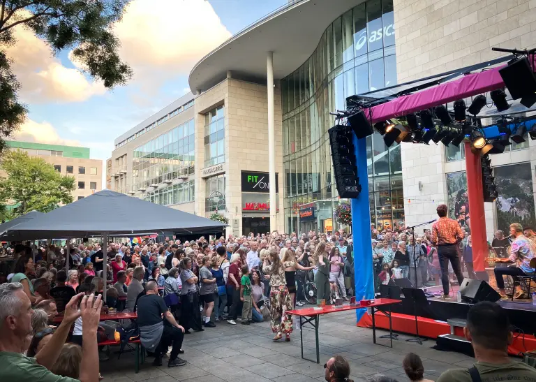 Der Alte Markt in Dortmund. Im Vordergrund ist eine Bühne mit einer Band zu sehen, im Hintergrund viele Menschen, die zuschauen.