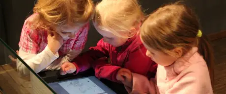 Drei Mädchen stehen an einem Multimediatisch im Museum für Kunst und Kulturgeschichte
