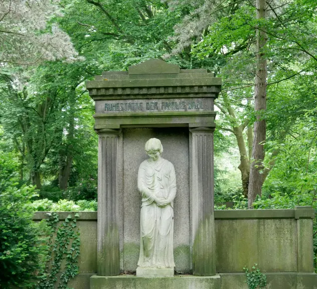 Grabstätte der Familie Wahl. Mittig ist eine Frauenstatue eingerahmt von zwei Steinsäulen in antikem Muster.