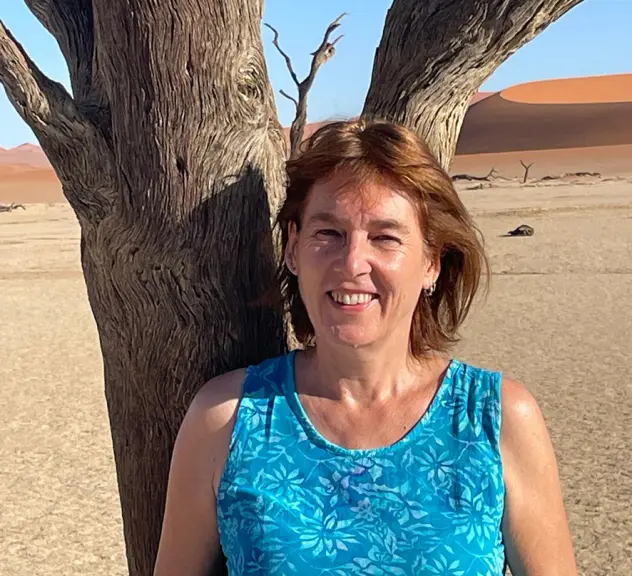Die Referentin Bettina Wachter steht lächeln in der Wüste Namibias