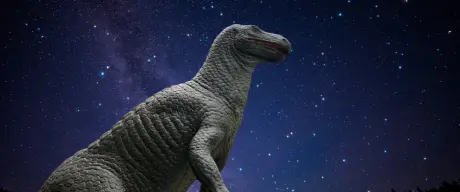 Ein Dinosaurier (Iguanodon) vor einem strahlenden Sternenhimmel