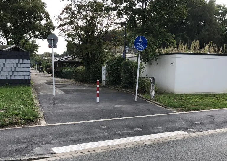 Bordabsenkung zwischen einer Straße und einem Geh- und Radweg.