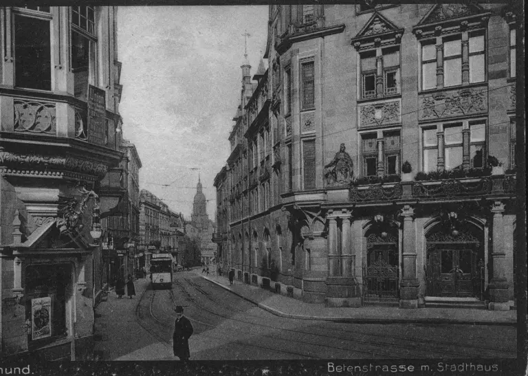 Die Betenstraße mit dem Stadthaus 1915, die Straßenbahn fährt die Straße entlang Fußgänger laufen über den Bürgersteig