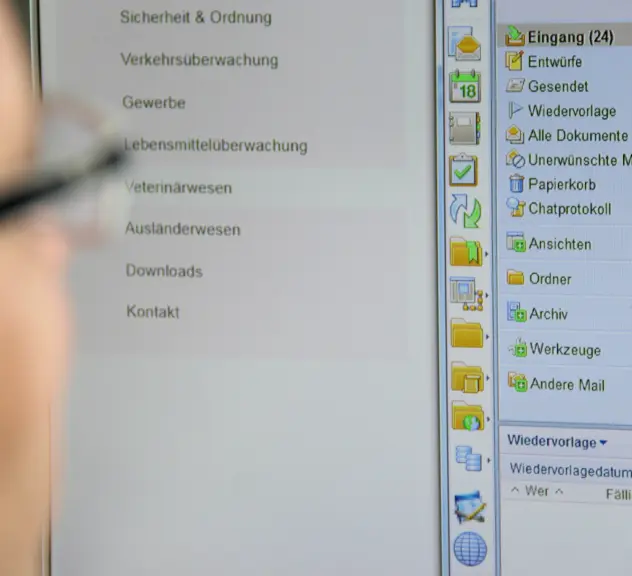 Ein Mann mit Brille schaut auf einen Computerbildschirm, auf dem ein Mailprogramm geöffnet ist.