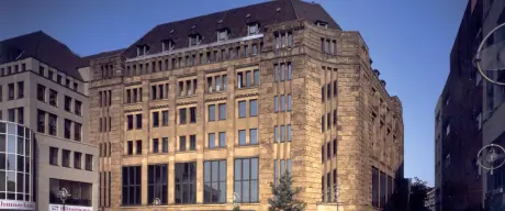 Ein historisches, steinernes Gebäude mit markanter Fassade und großen Fenstern.