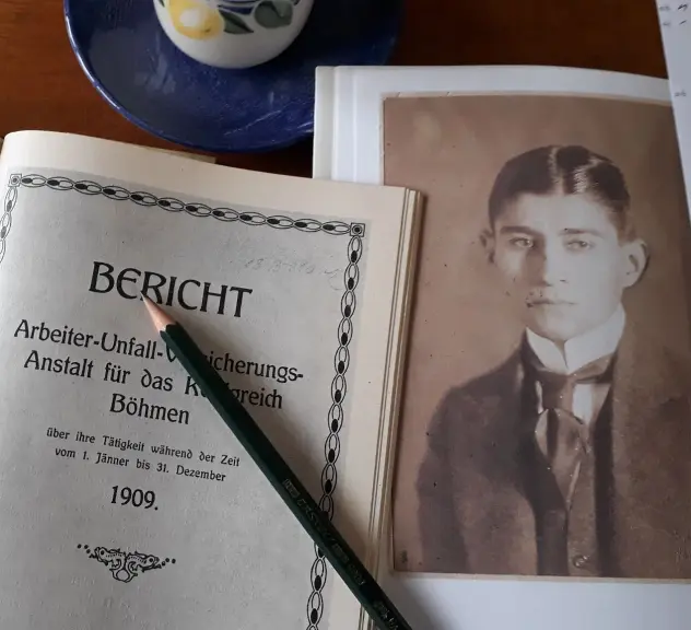 Ein Foto auf dem ein Bild des jungen Kafka und ein Buch zusehen sind