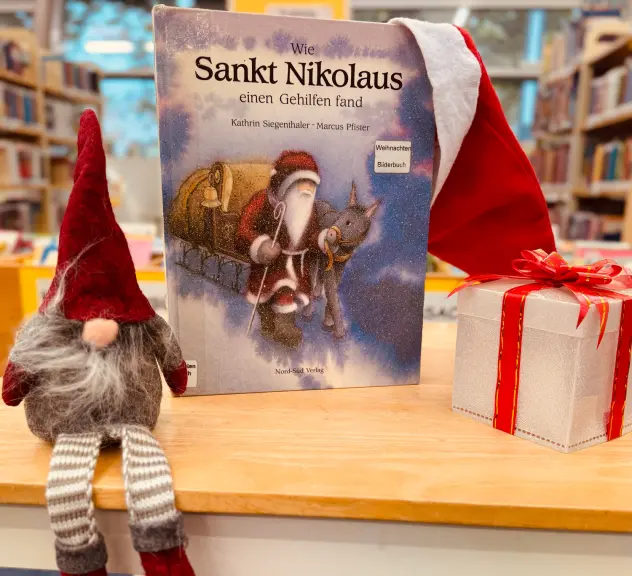 Ein Buch, ein Wichtel und ein Paket auf einem Tisch