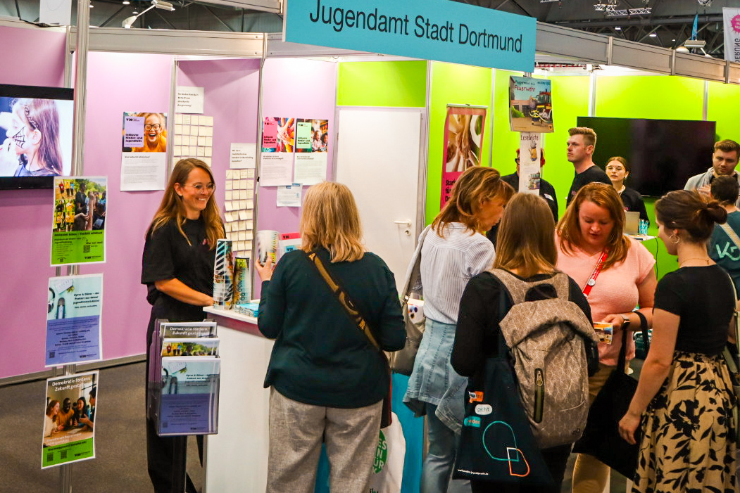 Menschen an einem Messestand des Jugendamtes Dortmund.