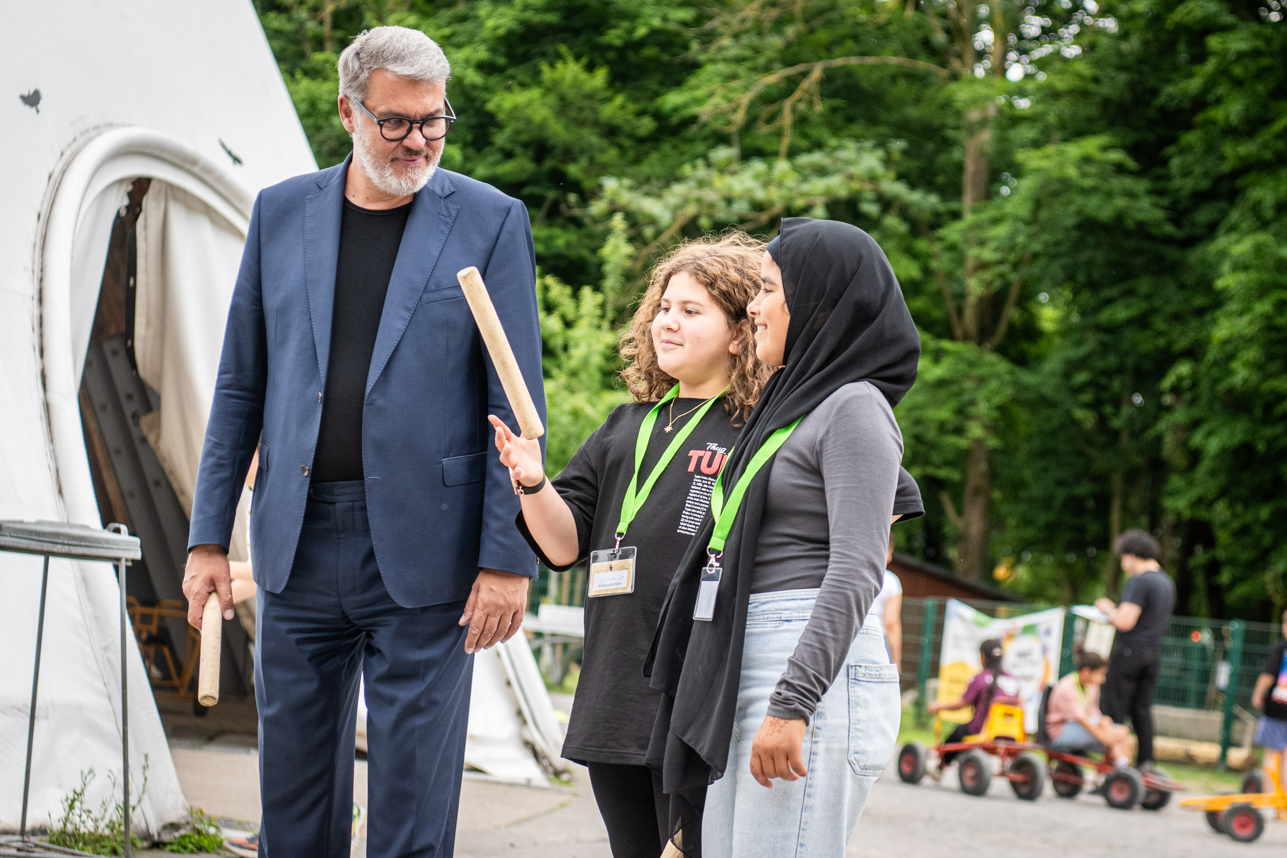 Oberbürgermeister Thomas Westphal steht neben zwei Mädchen neben dem Eingang zum Big Tipi im Fredenbaumpark